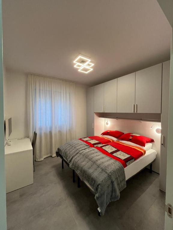 ein Schlafzimmer mit einem großen Bett mit roten Kissen in der Unterkunft B&B Alessandro Room & Bathroom in private apartament in Arco