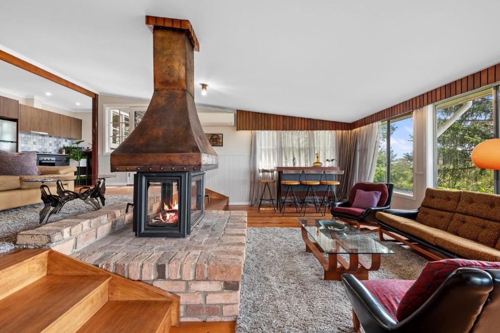 a living room with a fireplace and a couch at Sorata in Bilpin