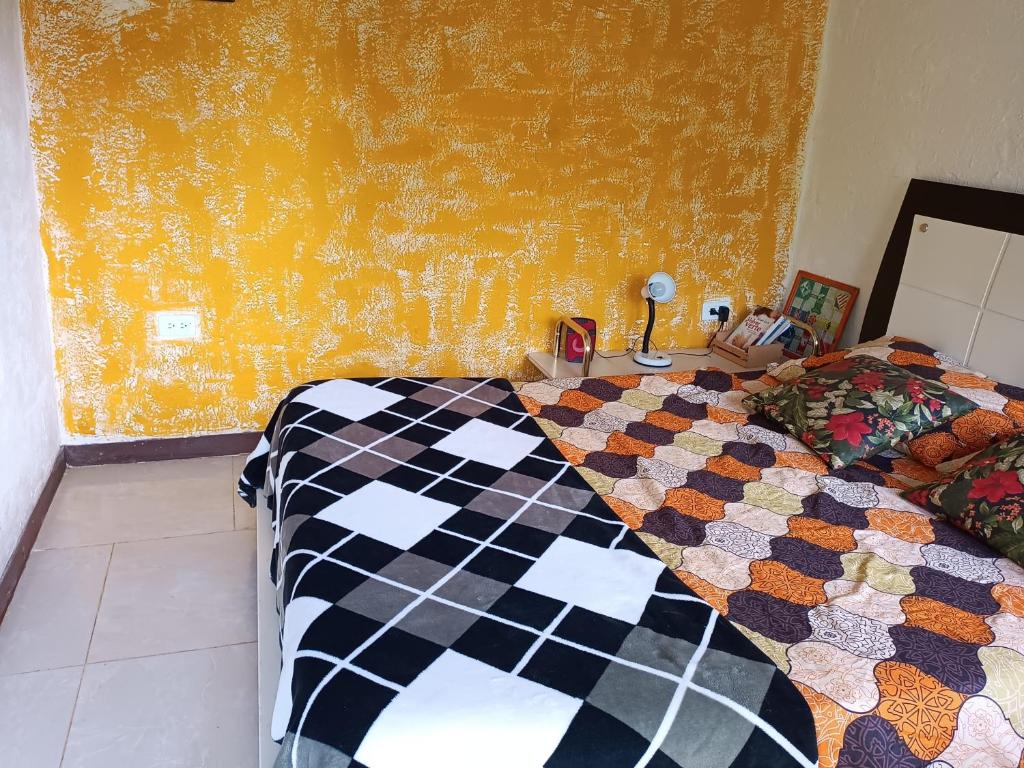 a bedroom with a bed with a checkered blanket at Cabaña en el Campo in La Vega