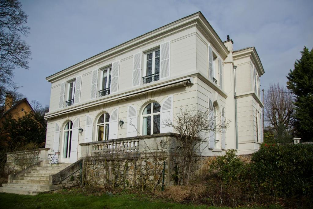 een oud wit huis met een hek ervoor bij Home Sweet Home - Celle Saint Cloud Versailles in La Celle-Saint-Cloud