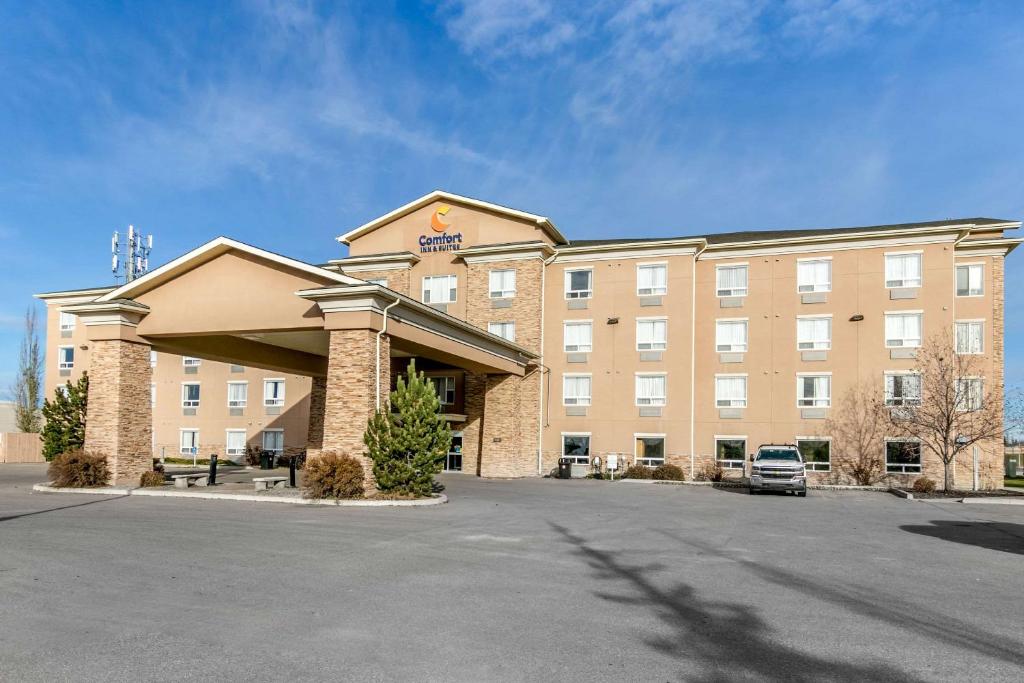 a hotel with a parking lot in front of it at Comfort Inn & Suites in Airdrie