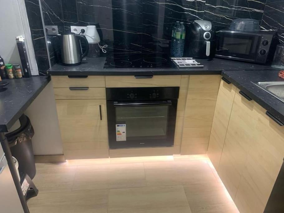 a kitchen with an oven with a light on the floor at Cosy Home Next To Disneyland & Train in Torcy