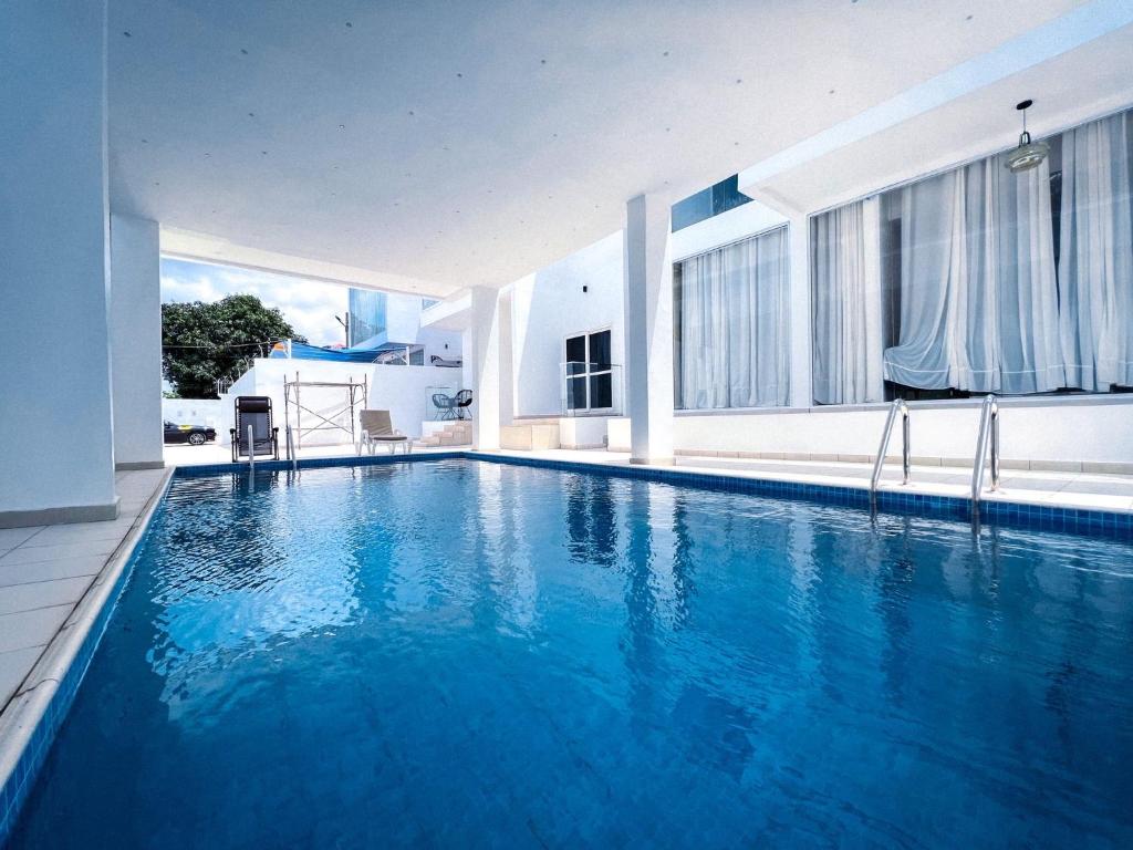 a swimming pool with blue water in a building at The Vittins in Tantra Hill