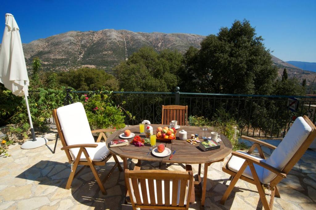 a table and chairs with a bowl of fruit on it at Avvisania Villa in Ayia Evfimia