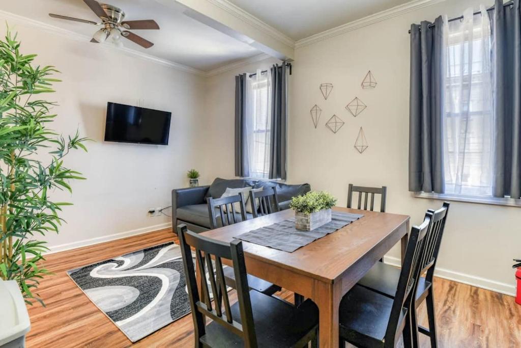 a dining room with a table and chairs and a couch at Modern 3BR2BA Apartment Minutes to NYC in Jersey City