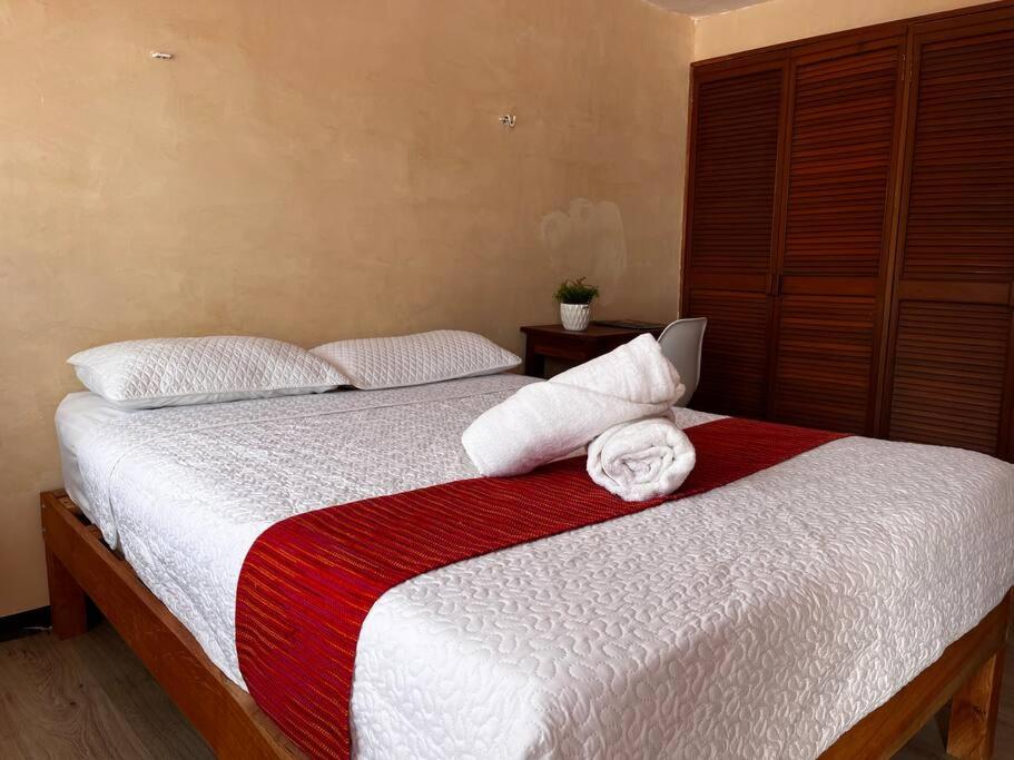 een slaapkamer met een bed met een rode en witte deken bij Suite 5 -Terraza Vista Gran Parque de la Plancha in Mérida