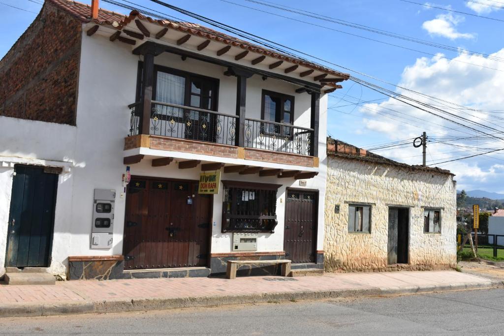 um edifício branco com uma varanda numa rua em Confortable apartamento cerca de la plaza principal em Villa de Leyva