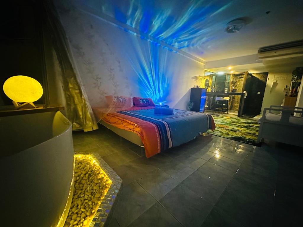 - une chambre dotée d'un lit avec des lumières bleues dans l'établissement High Floor Seaview Beach Apartments-tub face to Ocean,projector,high speed Wi-Fi, à Jomtien Beach