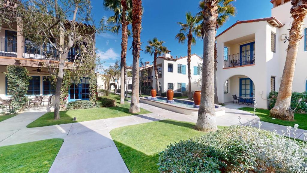 een loopbrug voor een gebouw met palmbomen bij LV002 Secluded Downstairs Legacy Villas Studio in La Quinta