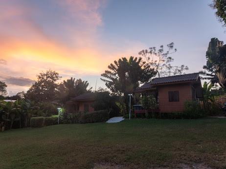 ein Haus in einem Garten mit Sonnenuntergang im Hintergrund in der Unterkunft Bansuan viewpai in Pai