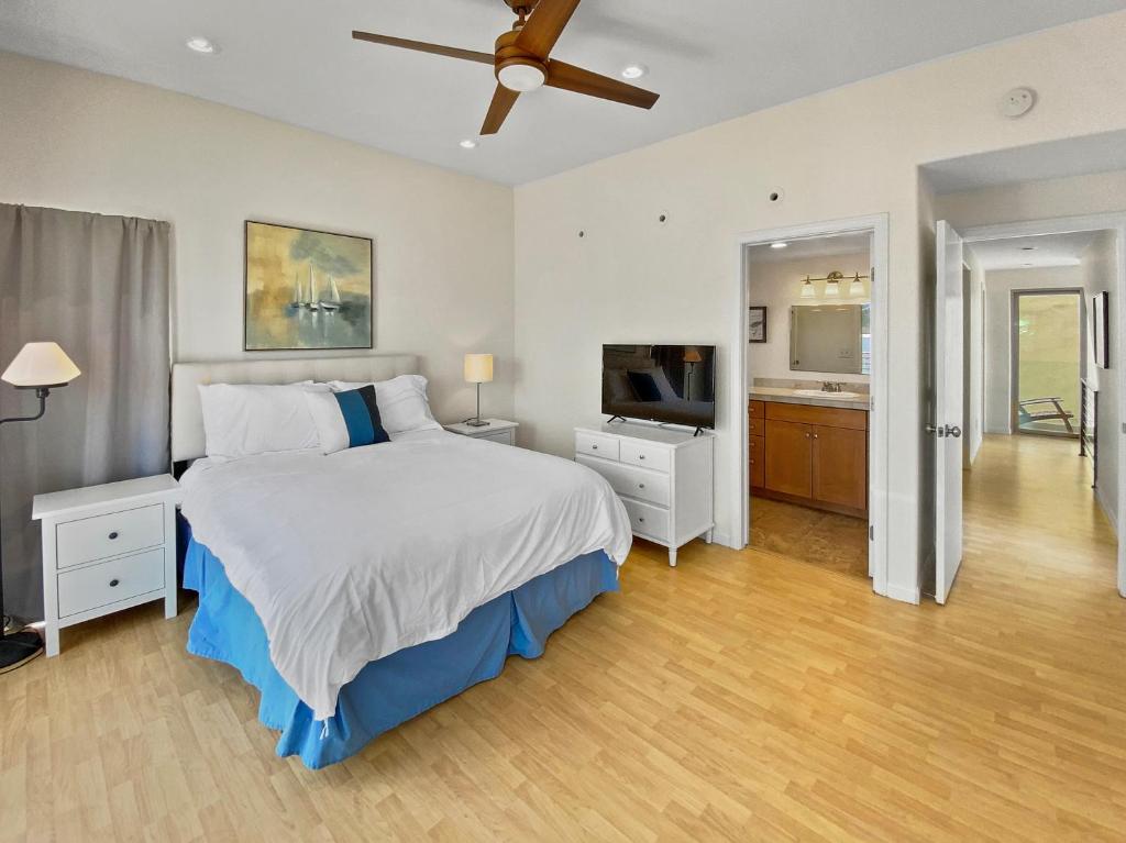 a bedroom with a bed and a flat screen tv at Ostend Escape - Multiple Patios, Large Rooftop, Water Views, Garage & Fast Wifi in San Diego