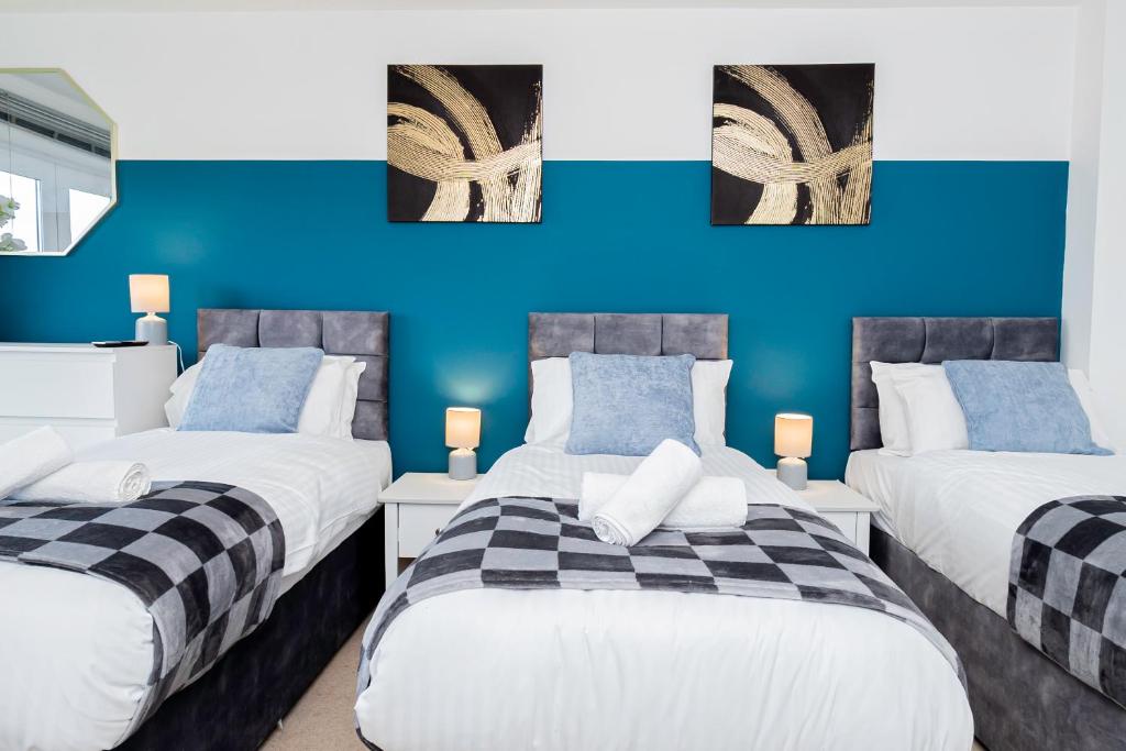 two beds in a room with blue walls at Wow BooK ME 9 beds 25 Baths CONTRACTORS,FAMILY! in Earley