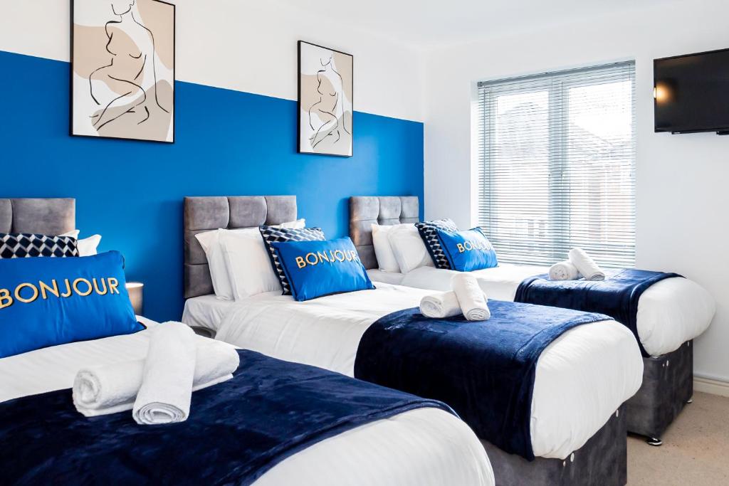 a room with four beds with blue walls at Wow Book Me 9 Beds 25 Baths Contractors,family! in Earley