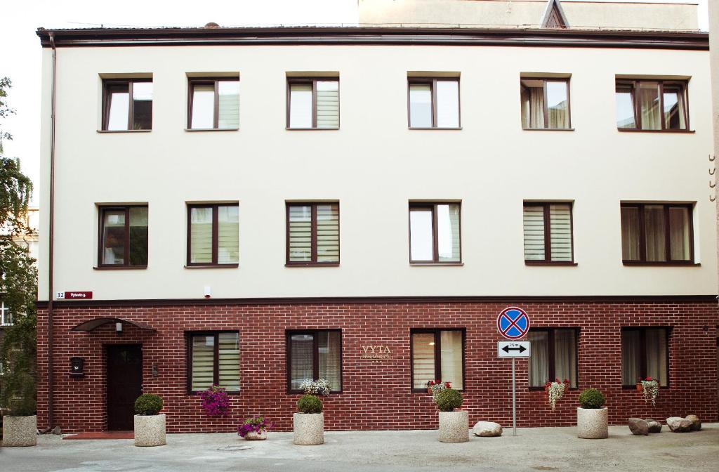 um grande edifício branco com tijolo vermelho em Apartamentai Vyta em Klaipėda