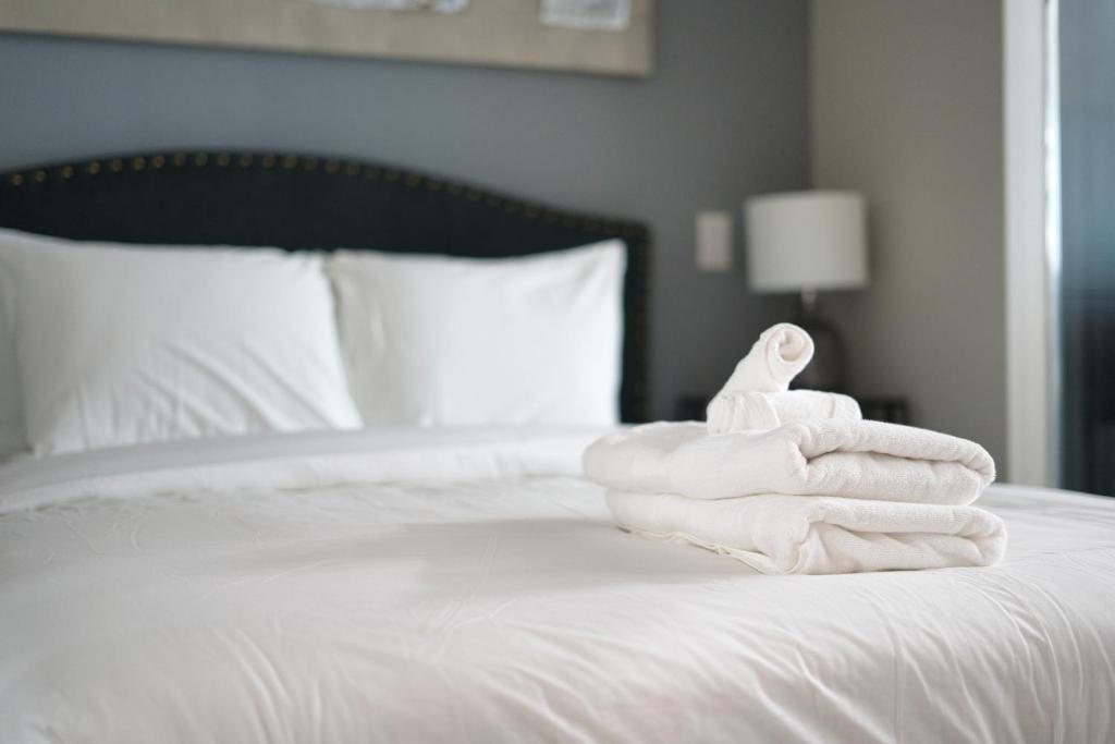 sterta ręczników na łóżku w obiekcie Modern 1 bedroom sleeps 3 Yorkville STK w mieście Toronto