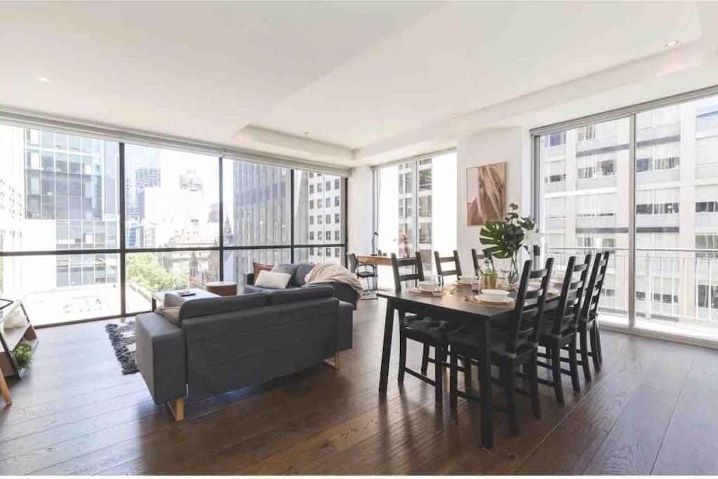 a living room with a couch and a table at Bright City Views Melbourne Central Penthouse on Collins in Melbourne