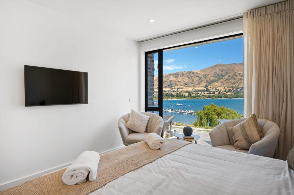 a bedroom with a large bed and a large window at Lakeside Luxury Studio Apartment in Wanaka