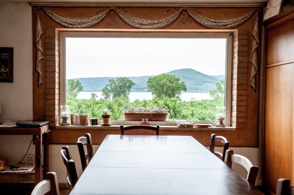 a table and chairs in a room with a large window at La Finestra sul Lago in Ronciglione