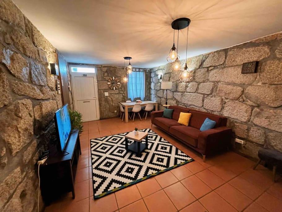 een woonkamer met een bank en een stenen muur bij Invited to Porto in Porto
