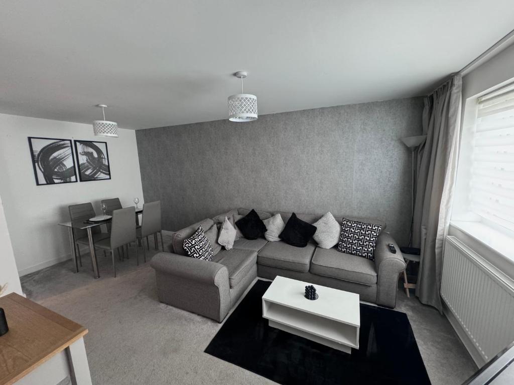 a living room with a couch and a table at Modern 2 bed city apartment with private parking in Swansea