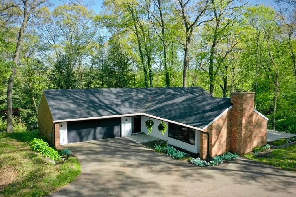 ein Backsteinhaus mit einem schwarzen Dach in der Unterkunft RiverEdge Haven Hot Tub, 5 Beds, Kayaks Near ND in Niles
