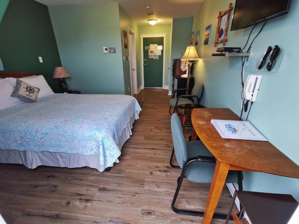 a room with a bed and a desk and a table at The Inn at Fisherman's cove in Halifax