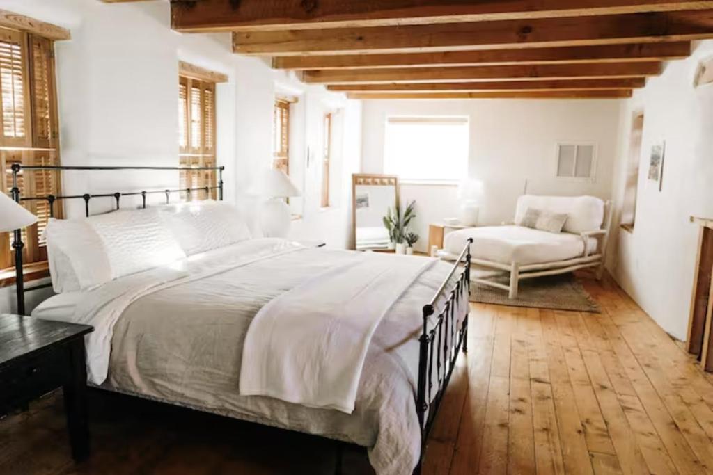 1 dormitorio con 1 cama grande y 1 silla en Group Getaway: Serene Adobe Retreat 4-11 guests en Albuquerque