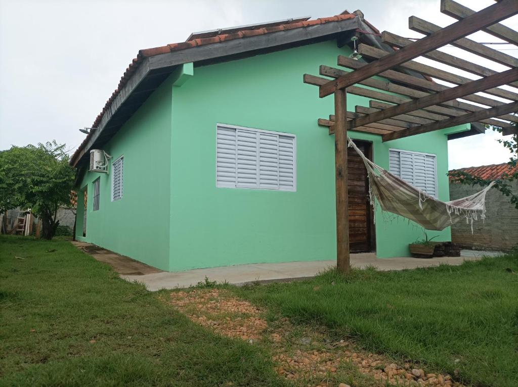 ein blaues Haus mit einer Hängematte davon in der Unterkunft Temporada em família e amigos. in Barra do Garças