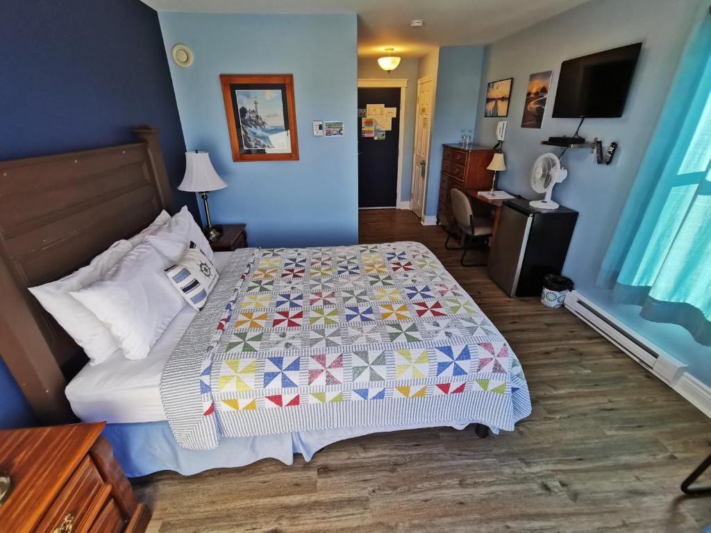 a bedroom with a bed with a quilt on it at The Inn at Fisherman's cove in Halifax