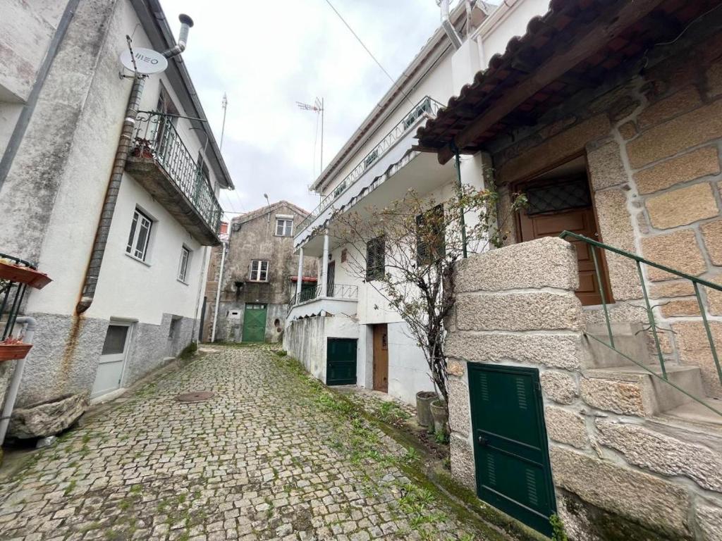 un vicolo in un vecchio edificio con una porta verde di Cosy Home Near Serra da Estrela a Gouveia