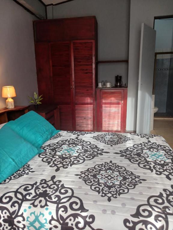 a bedroom with a bed with a black and white comforter at Habitaciones el mirador in San José