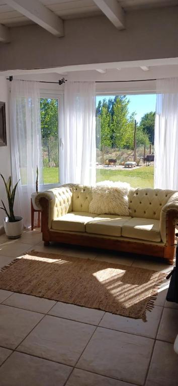 a couch sitting in a living room with a window at Casa de Balsa in Neuquén