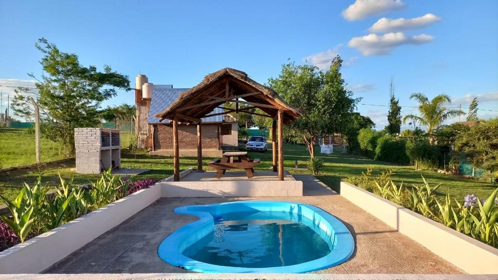 - une piscine au milieu d'un patio avec un kiosque dans l'établissement CABAÑA B COMPLEJO AIRES SERRANOS 2 a 3 PERSONAS TANTI, à Córdoba