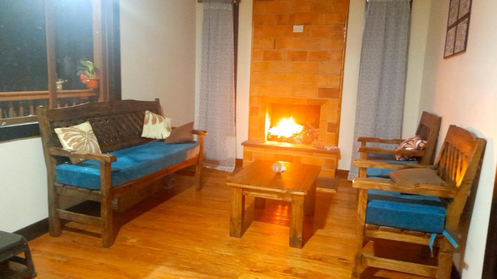 a living room with a couch and a fireplace at Rancho Valle del Rio in Cuenca