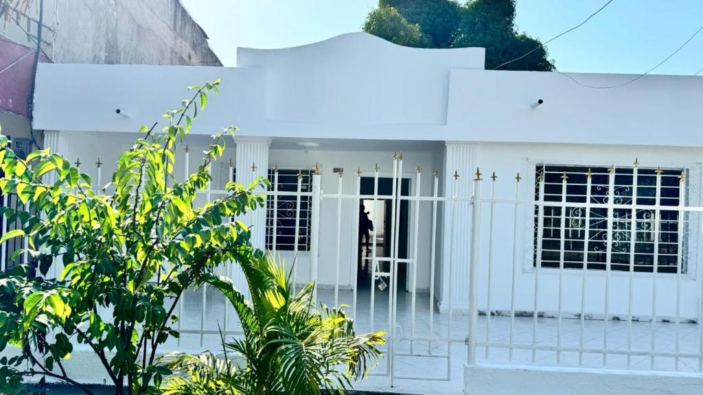a white house with a gate in front of it at Marbar Cartagena Hostel in Cartagena de Indias