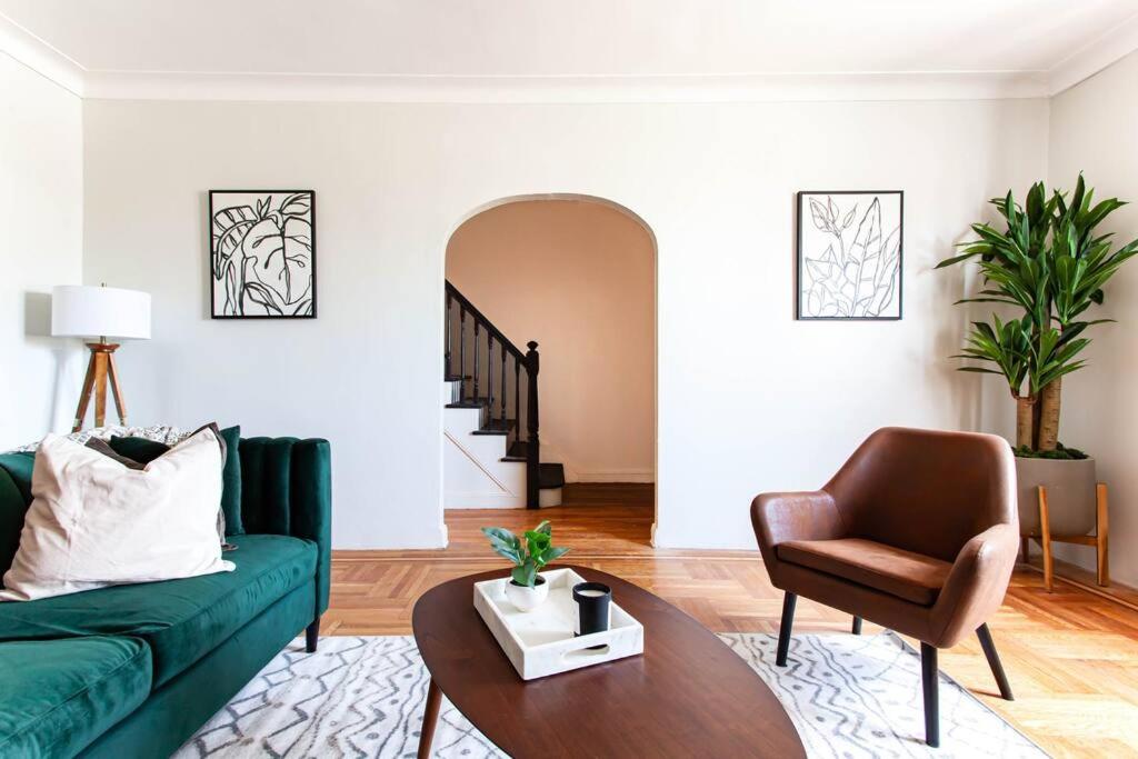 a living room with a green couch and a chair at 4 Bedroom Sun Drenched & Designer Home in Brooklyn