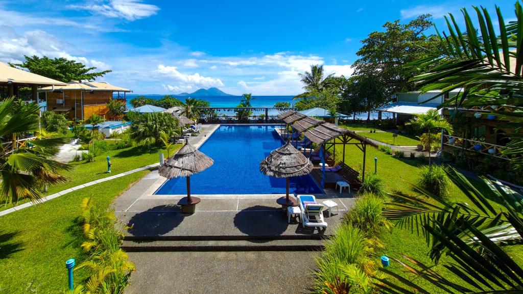 uma vista aérea de uma piscina de resort com guarda-sóis em Rapopo Plantation Resort em Kokopo