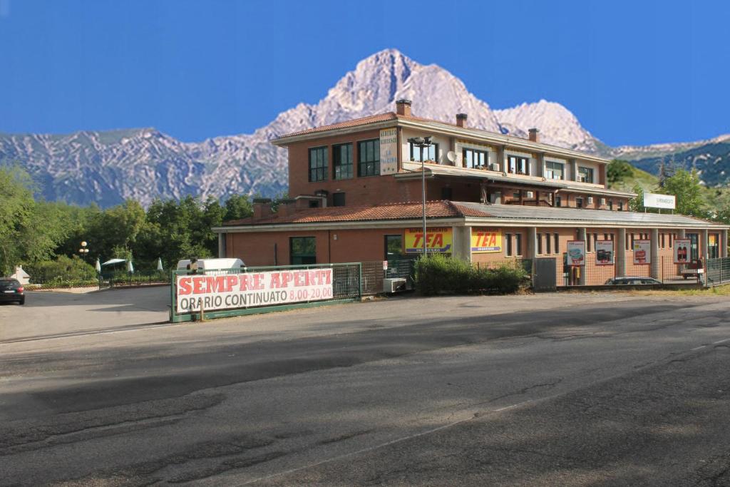 a building with a sign in front of a mountain at Residence La Piscina in Isola del Gran Sasso dʼItalia