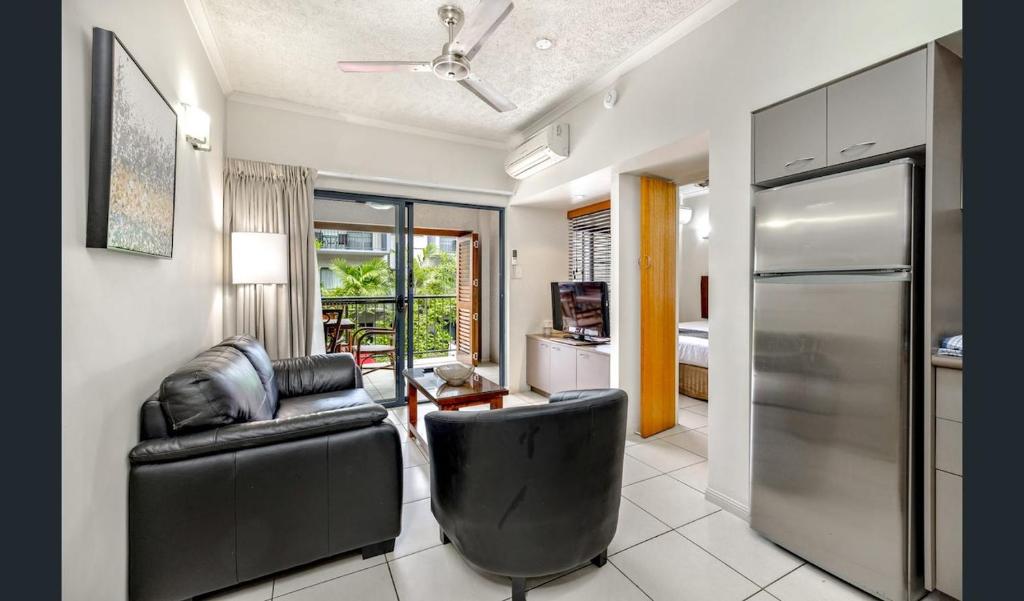 een woonkamer met een bank en een koelkast bij Southern Cross Atrium Apartments in Cairns