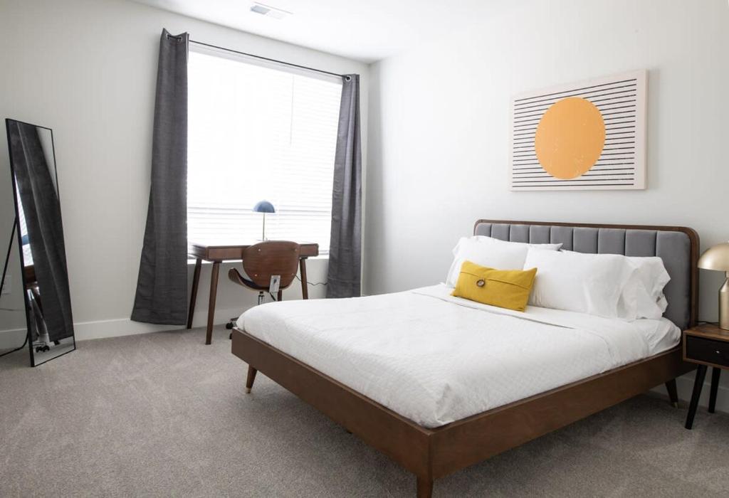 CozySuites Stunning 3BR in Downtown Cincinnati في سينسيناتي: غرفة نوم عليها سرير ومخدة صفراء