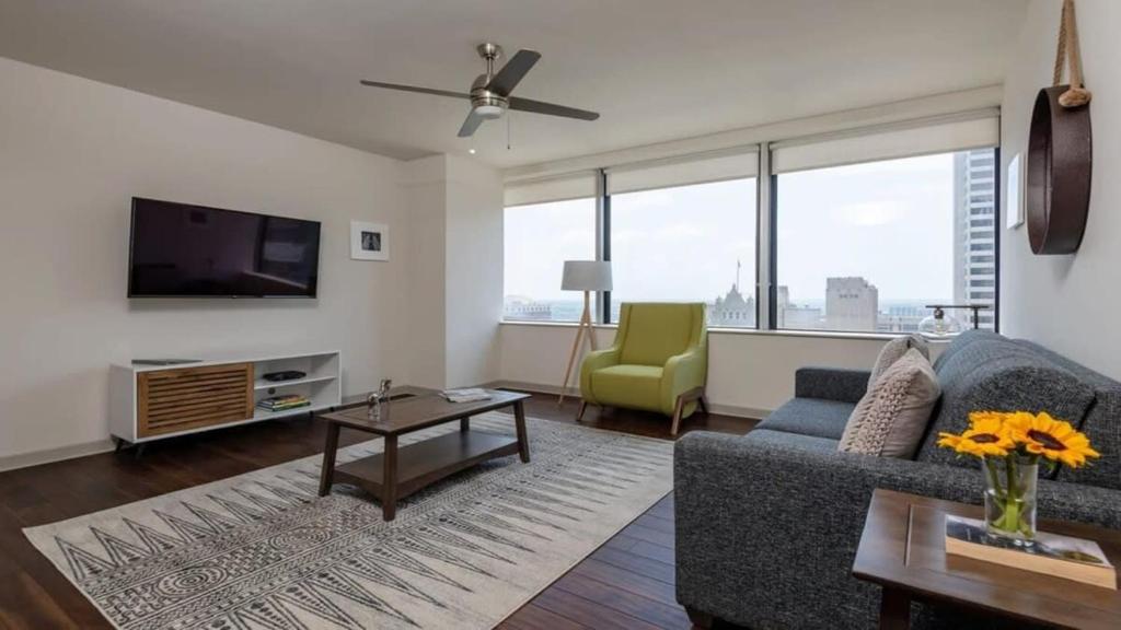 a living room with a couch and a tv at 16th FL Bold CozySuites with pool, gym, roof #3 in Dallas