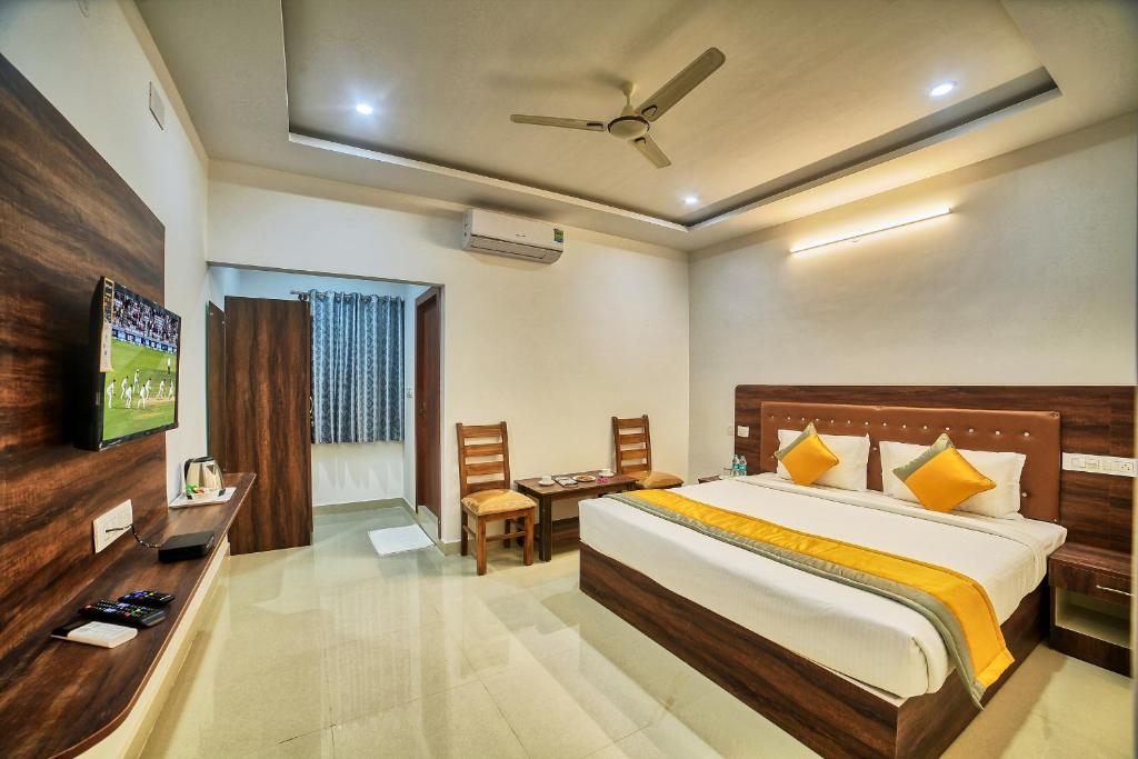 um quarto de hotel com uma cama e uma televisão em HOTEL VISA INN NEAR KEMPEGOWDA AIRPORT em Bangalore