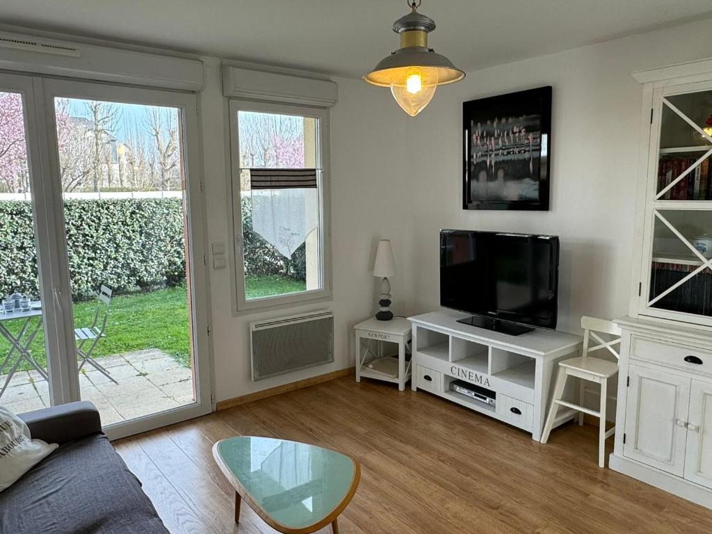 een woonkamer met een flatscreen-tv en een bank bij Appartement Cabourg, 2 pièces, 4 personnes - FR-1-487-266 in Cabourg