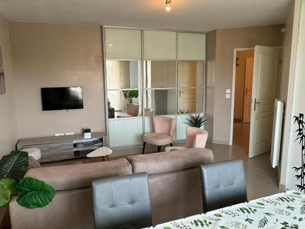 un salon avec un canapé et une télévision dans l'établissement Appartement Moderne près de la Plage et du Centre - 2 Chambres, Balcon, Parking, Animaux Acceptés - FR-1-487-363, à Cabourg
