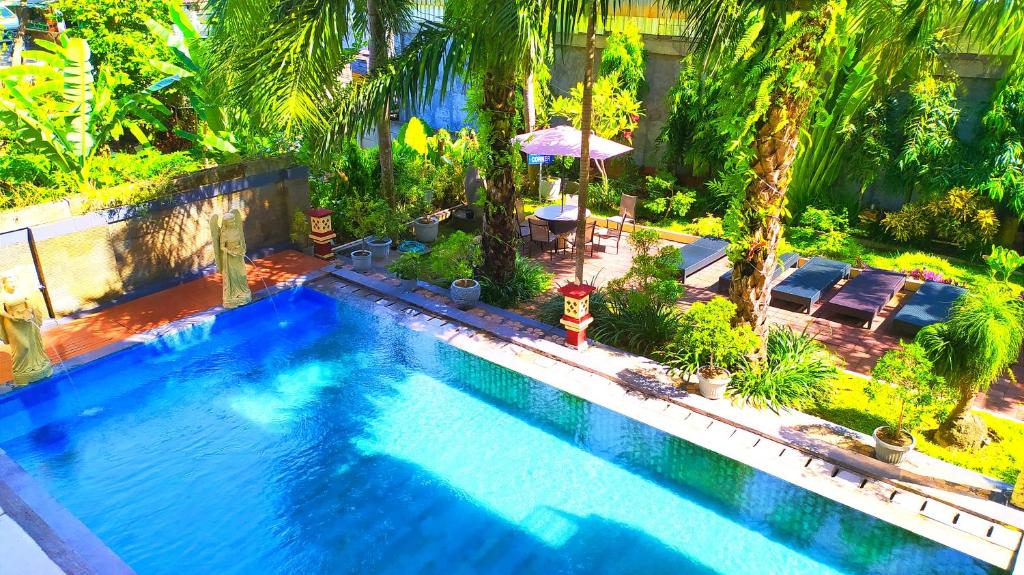 an overhead view of a swimming pool with palm trees at Puri Saron Denpasar Hotel in Denpasar