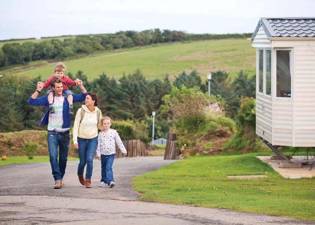 a family is walking down a road with their child at Stunning Home In Looe W- in Looe