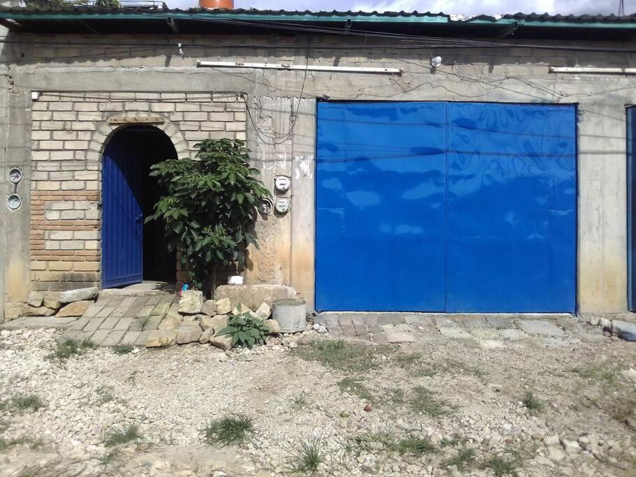 uma grande porta de garagem azul num edifício em Casa completa familiar, dos cuartos. em San Agustin de las Juntas