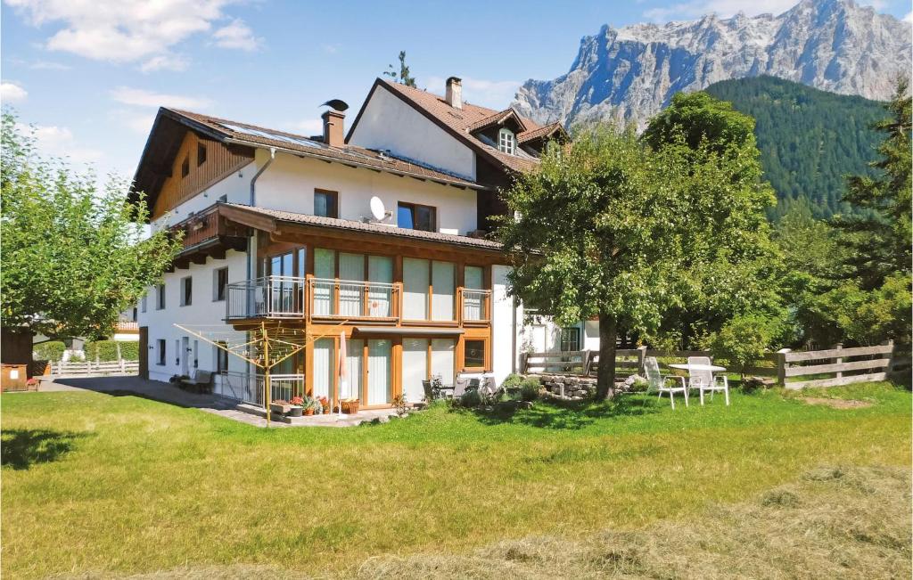 a house in a field with mountains in the background at Cozy Apartment In Ehrwald With House A Mountain View in Ehrwald