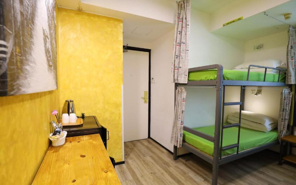 um quarto com 2 beliches e uma mesa em Yesinn @YMT em Hong Kong