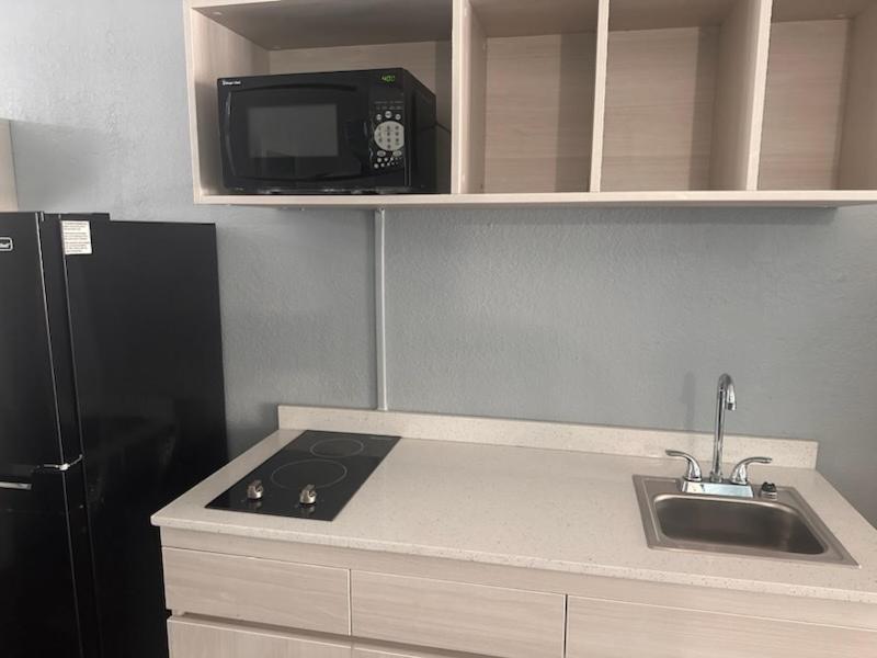 a kitchen with a sink and a microwave and a refrigerator at Suburban Studios by Choice Hotels- All American Staff - Ultra Sparkling - In-Room Kitchens - Sparkling Rooms - I-95 - Exit 36 - Special Rates - Smoking and Non Smoking Rooms - Stay & Save Today in Brunswick